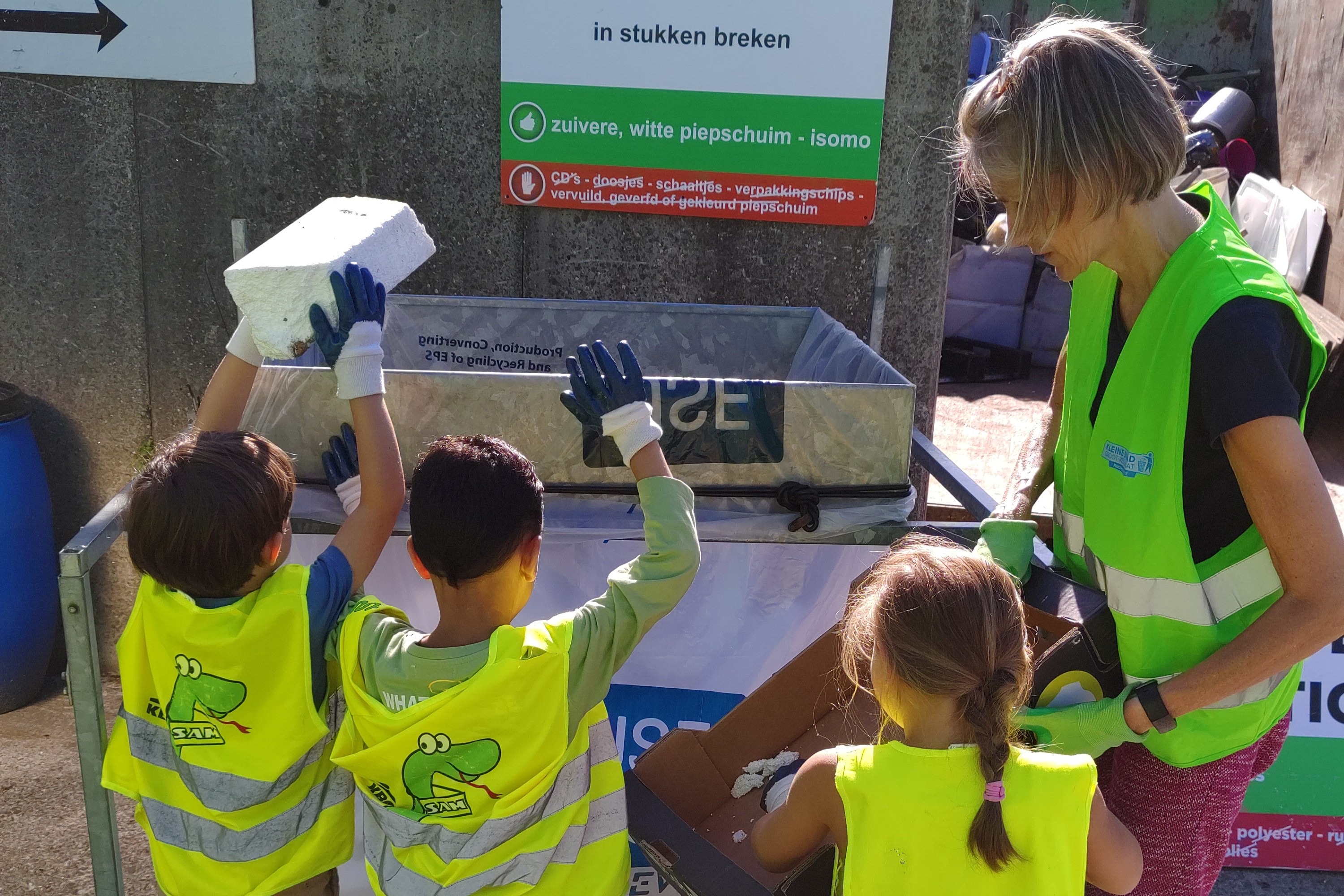 Juf Karen samen met kleuters op het recyclagepark